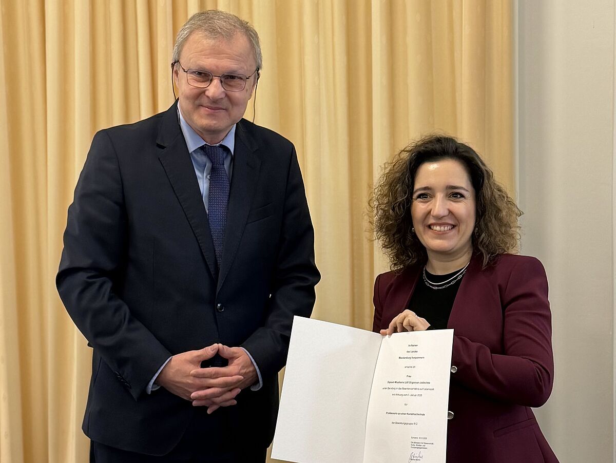 Der Abteilungsleiter für Wissenschaft, Forschung, Hochschulen, Woldemar Venohr, überreicht Prof. Diplom-Musikerin Lilit Grigoryan ihre Ernennungsurkunde. © privat